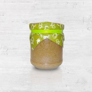 een klein potje gevuld met groene olijven tapenade